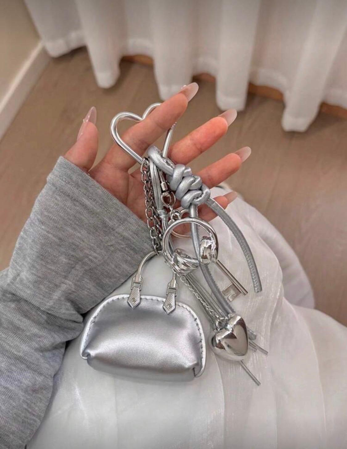 سلسلة مفاتيح صغيرة أنيقة  على شكل حقيبة فضية .