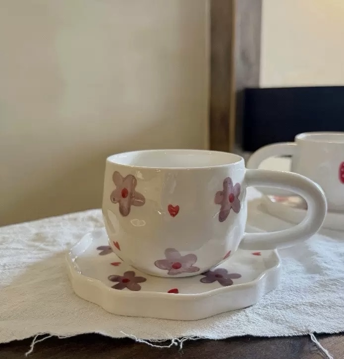 مج مرسوم عليه أزهار بنفسجية وقلوب حمراء .